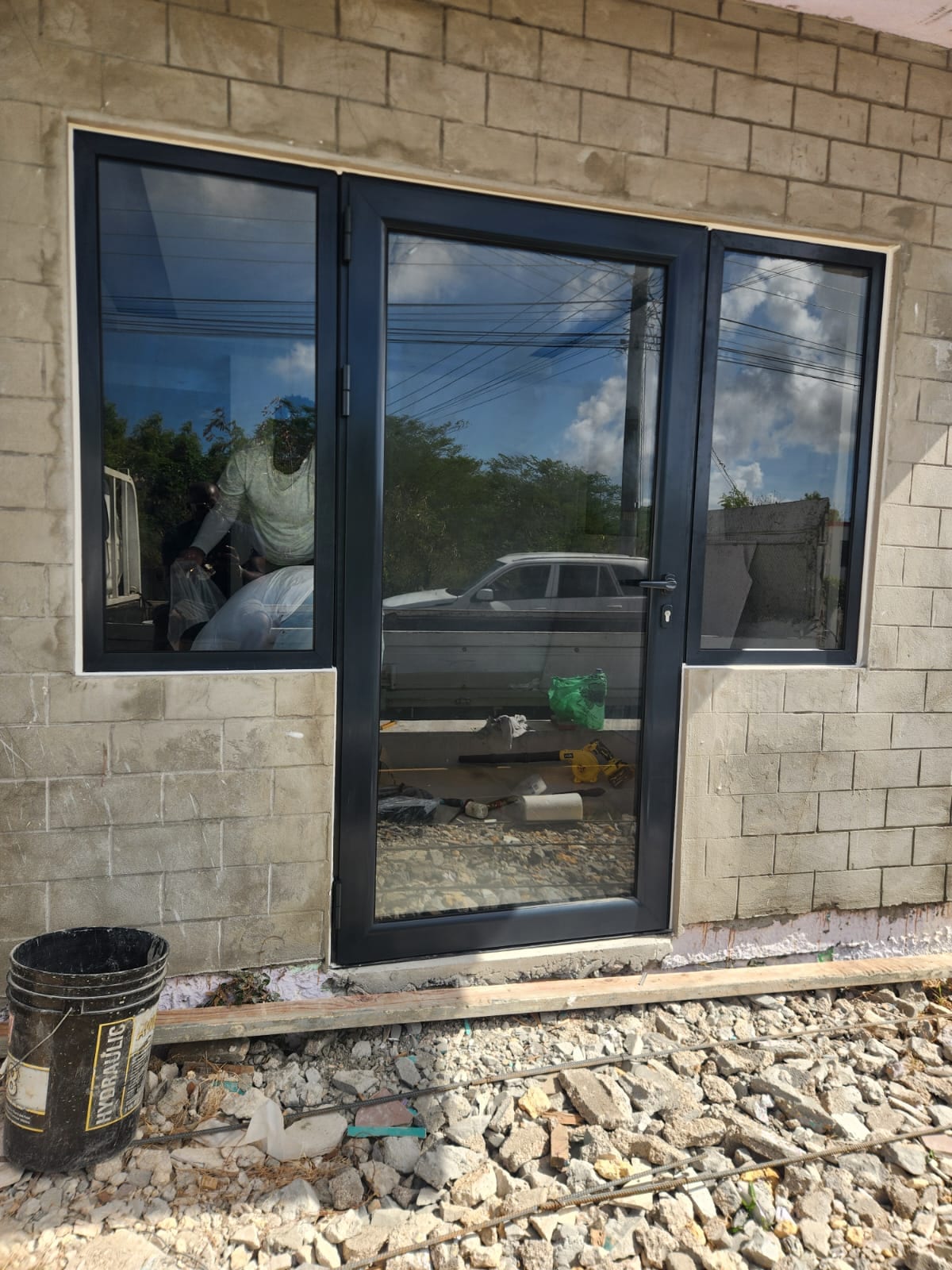 Charcoal grey aluminium entry door with full-height glazed sidelights in Anguilla