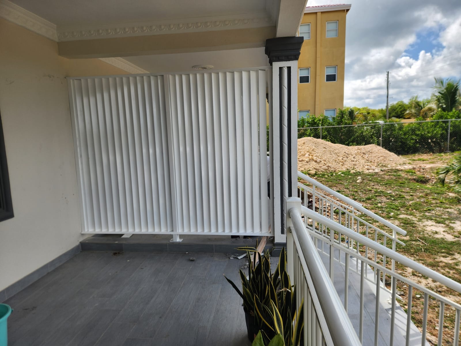 White adjustable aluminium louvre privacy screen enclosing a balcony in Anguilla